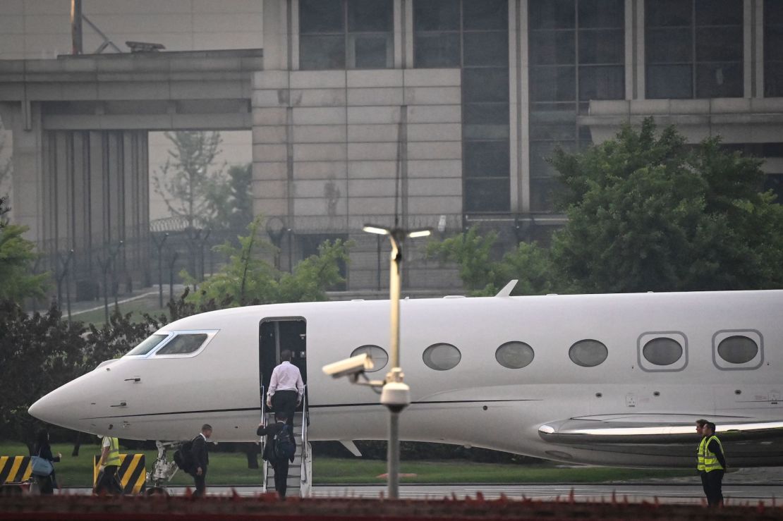 Elon Musk (in white) boards his private jet before departing from Beijing Capital International Airport on May 31, 2023. He was traveling to Shanghai.