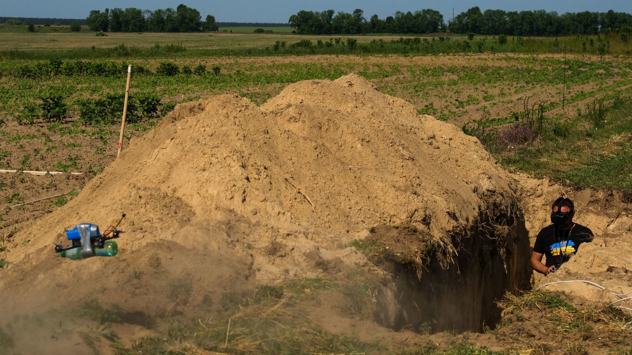 An operator launches his drone while standing in a makeshift trench during a UAV competition organized by the Ukrainian government.