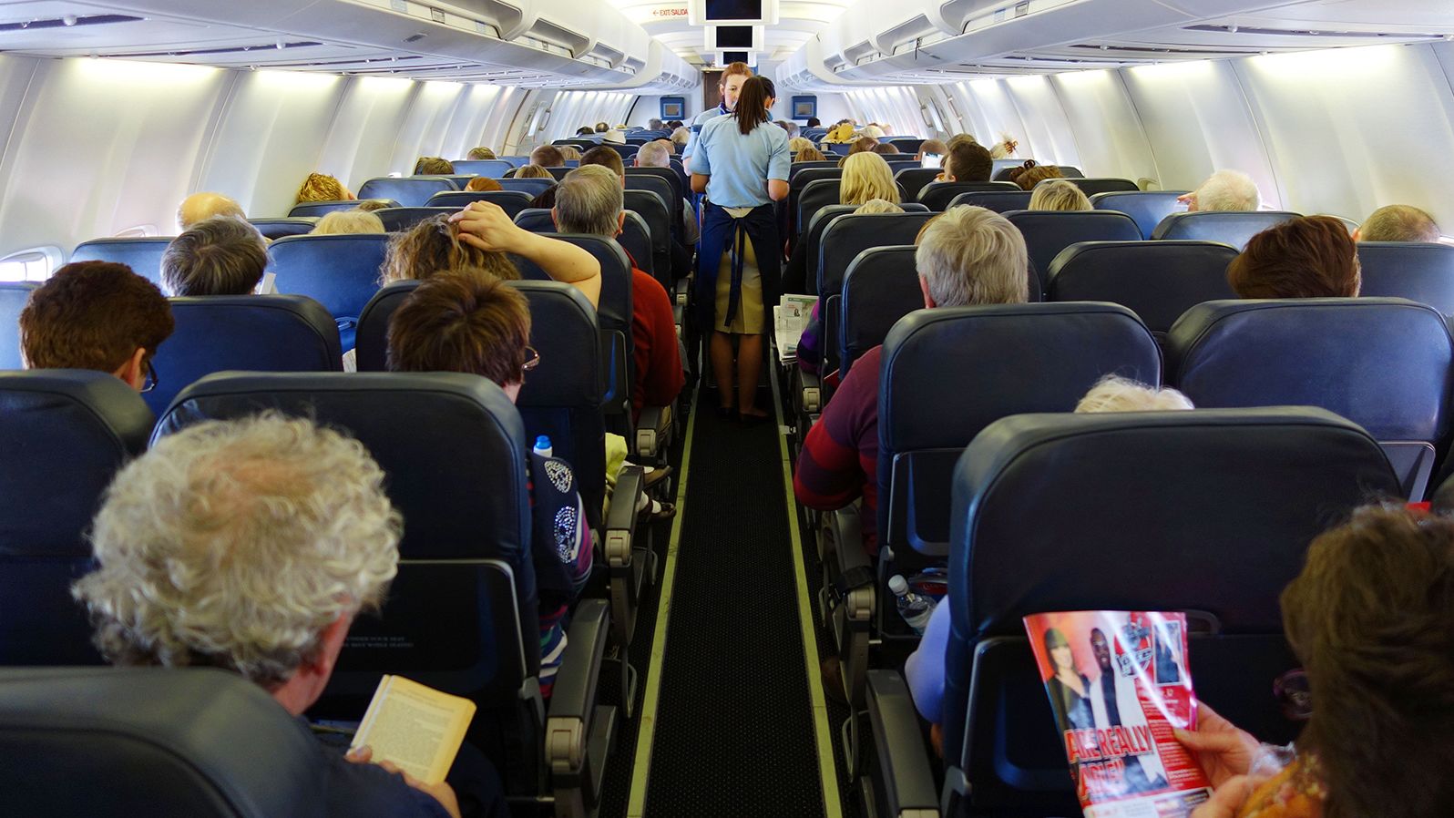 D91B8X Passengers on a aeroplane, interior of seating area on aircraft, passengers in economy seats during flight