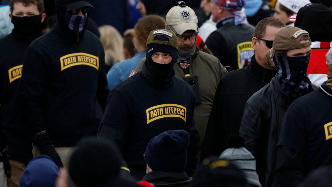 In this photo from January 6, 2021, David Moerschel, who is in the center wearing a backwards-facing cap that says "Oathkeeper," leaves a rally at the Ellipse in Washington, DC. 