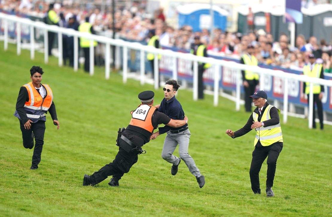 A protestor was tackled by police and stewards on the racetrack.