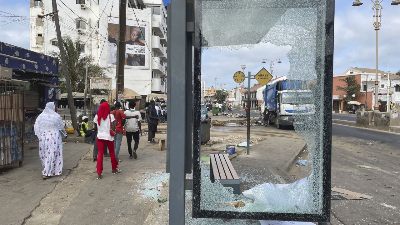People walk past a bus shelter shattered during clashes between supporters of Senegal opposition leader Ousmane Sonko and security forces, after Sonko was sentenced to prison in Dakar, Senegal  June 3, 2023.