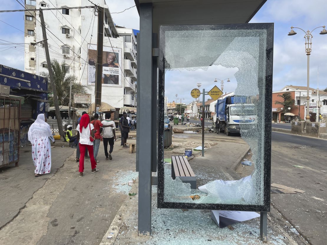 People walk past a bus shelter shattered during clashes between supporters of Senegal opposition leader Ousmane Sonko and security forces, after Sonko was sentenced to prison in Dakar, Senegal  June 3, 2023.