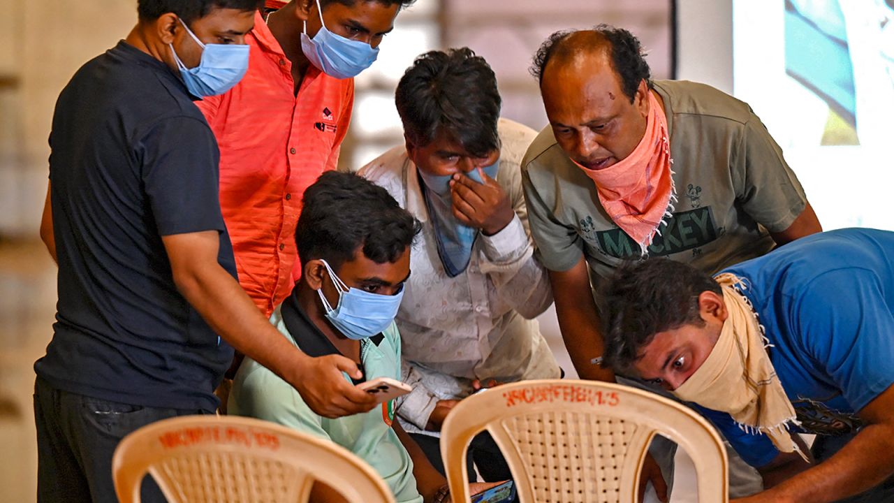 Family members look at photographs on a computer to identify bodies at a temporary mortuary following a train collision near Balasore, in India's eastern state of Odisha, on June 4, 2023. 