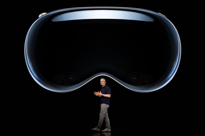 Cook speaks under an image of Vision Pro, a new mixed reality headset that the company unveiled in June 2023.