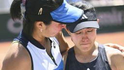 Japanese tennis player Miyu Kato (R) appears in shock as her Indonesian partner Aldila Sutjiadi wraps an arm around her shoulders, after the pair were disqualified in a women's doubles third round match at the French Open tennis tournament in Paris on June 4, 2023. The pair were forced to forfeit the match after Kato accidentally hit a ball girl with a ball between points. 