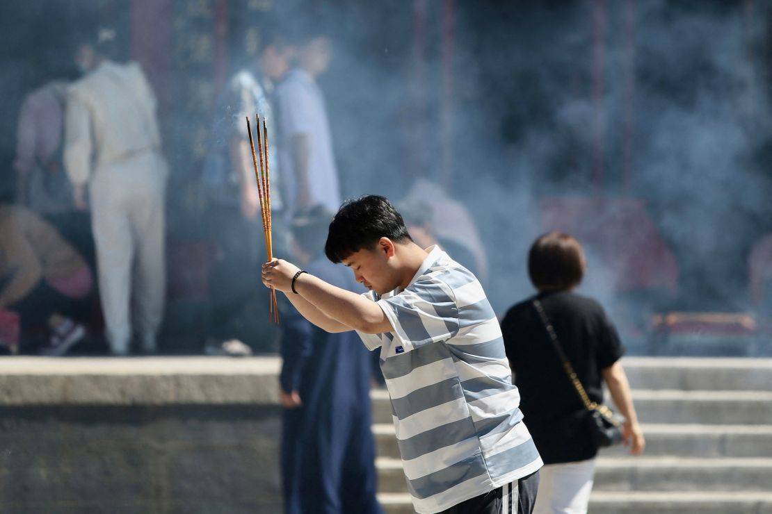 A student holds burning incense sticks as he prays for good results ahead of the gaokao at a temple in Shenyang, China. 