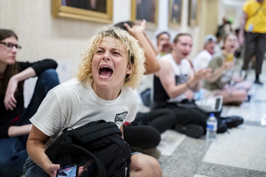 Maria White shouts "Where is Ron," as people walk past into Florida Gov. Ron DeSantis' office while dozens of activists stage a sit-in outside his office, Wednesday, May 3, 2023, in Tallahassee, Fla. Florida Republicans on Wednesday approved bills to ban diversity programs in colleges and prevent students and teachers from being required to use pronouns that don't correspond to someone's sex, building on top priorities of the Republican governor. (Alicia Devine/Tallahassee Democrat via AP)
