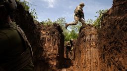A Ukrainian Army soldier jumps over a gap in a defensive trench outside Kostyanynivka, in the Donetsk region of eastern Ukraine, on May 24. 