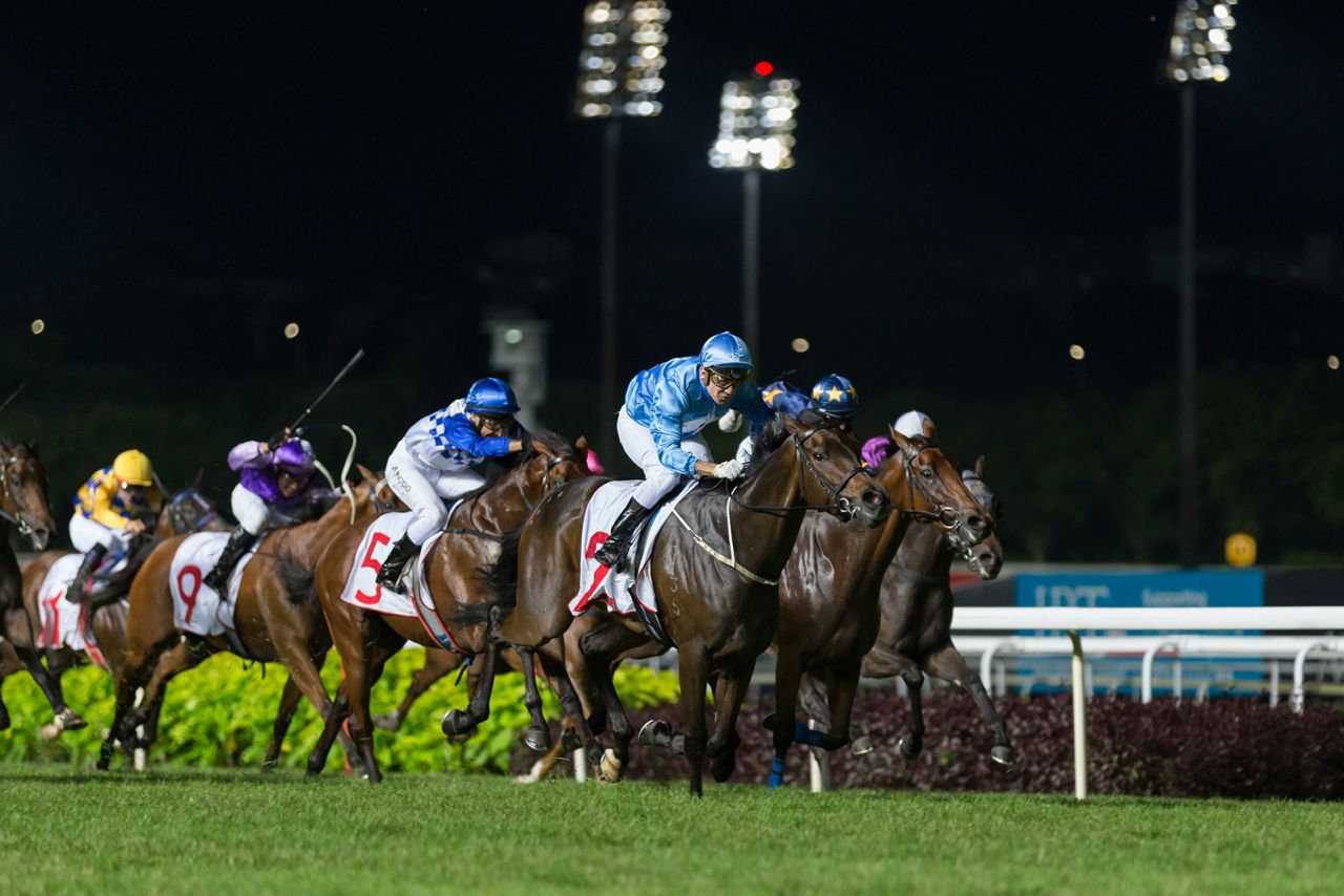 Jockeys sprint at Kranji Racecourse on May 25, 2019 in Singapore.