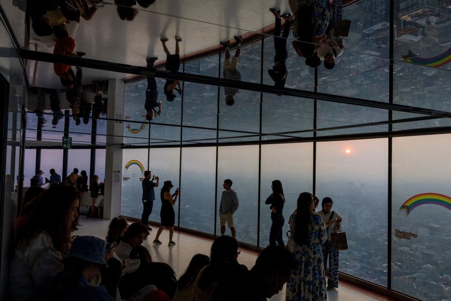 People at Toronto's CN Tower take photos of the smoky city on June 6.