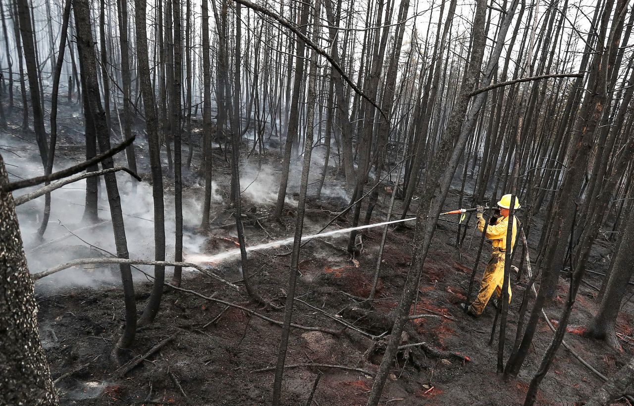 Firefighter Jason Rock sprays hot spots in the Birchtown area while tackling wildfires in Shelburne County, Nova Scotia, on June 3.