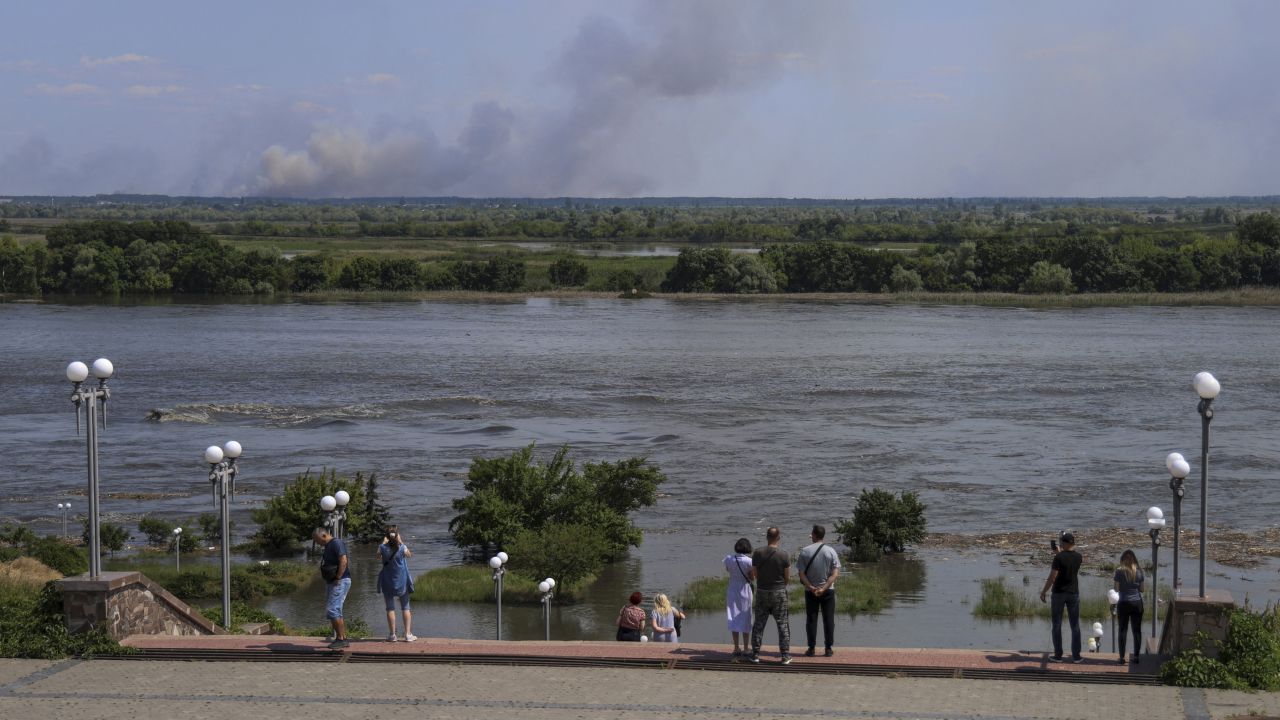 Local residents stand on the Dnipro embankment after the Nova Kakhovka dam breach on June 6.