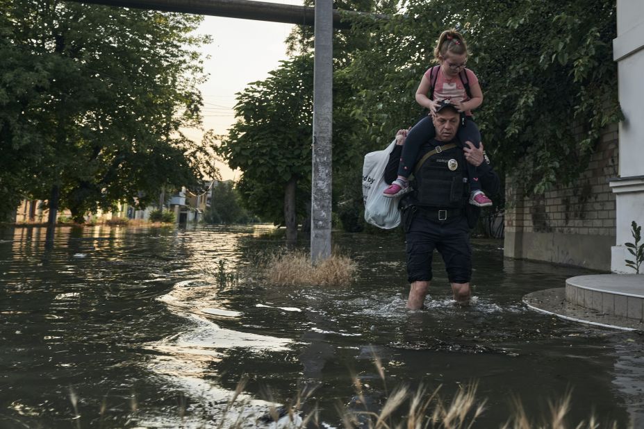 People make their way through floodwaters in Kherson.