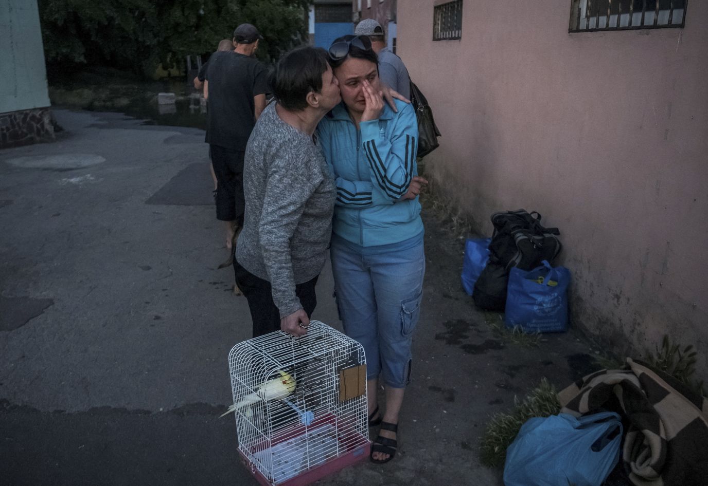 Local residents comfort each other following their evacuation from a flooded area.