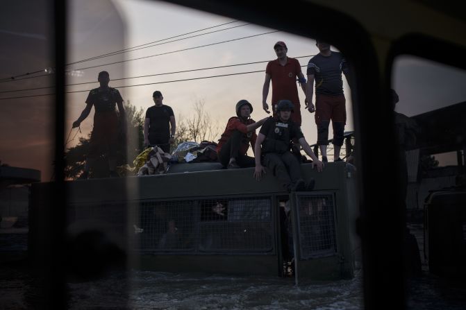 People in, and on, an army truck as emergency responders work during evacuations.