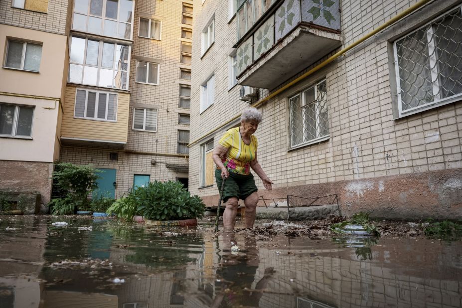 Local resident Oleksandra walks around her house on a flooded street in Kherson.