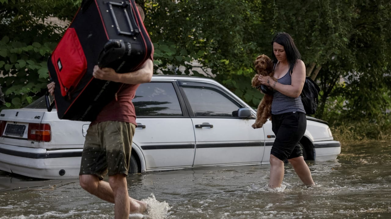 Local residents carry their personal belongings on a flooded street, after the Nova Kakhovka dam breached, amid Russia's attack on Ukraine, in Kherson, Ukraine June 6, 2023. REUTERS/Alina Smutko     TPX IMAGES OF THE DAY