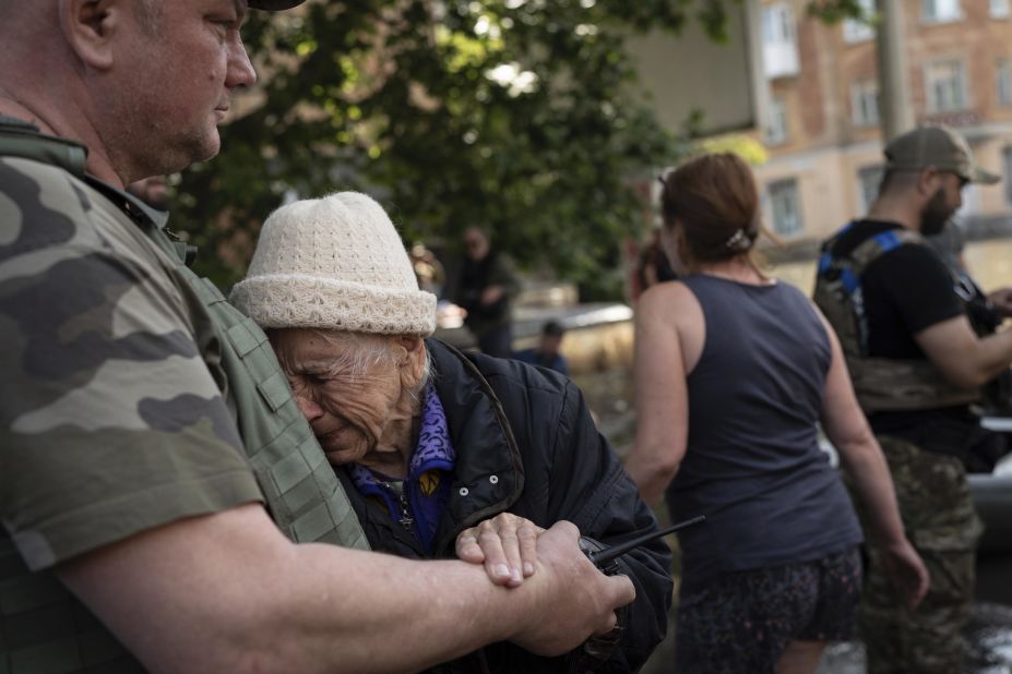 A woman is evacuated from a flooded neighborhood in Kherson.