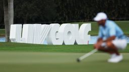 Signage is seen as Charl Schwartzel of Stinger GC lines up a putt on the fourth green during the team championship stroke-play round of the LIV Golf Invitational - Miami at Trump National Doral Miami on October 30, 2022 in Doral, Florida.