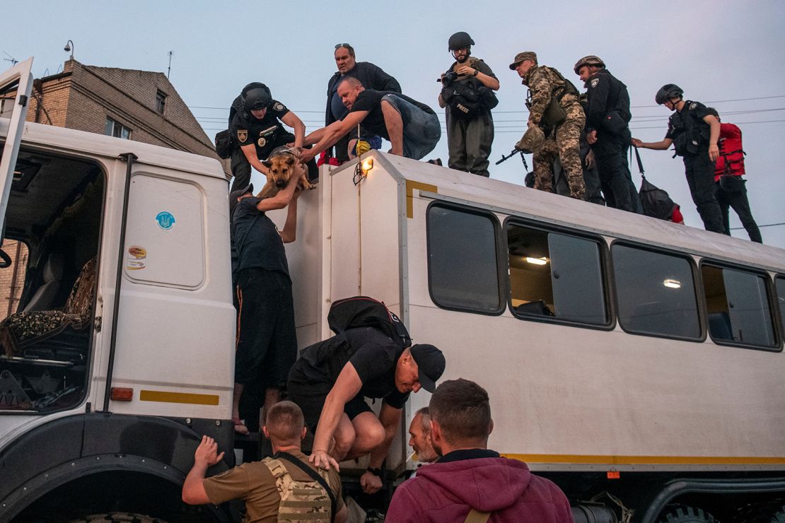Rescuers evacuate local residents from a flooded area after the Nova Kakhovka dam breached in Kherson, Ukraine, on June 6.