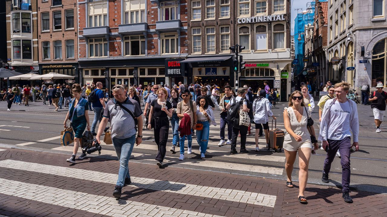 2JFPRX1 荷蘭阿姆斯特丹 — 2022 年 6 月 21 日：許多人在阿姆斯特丹過馬路