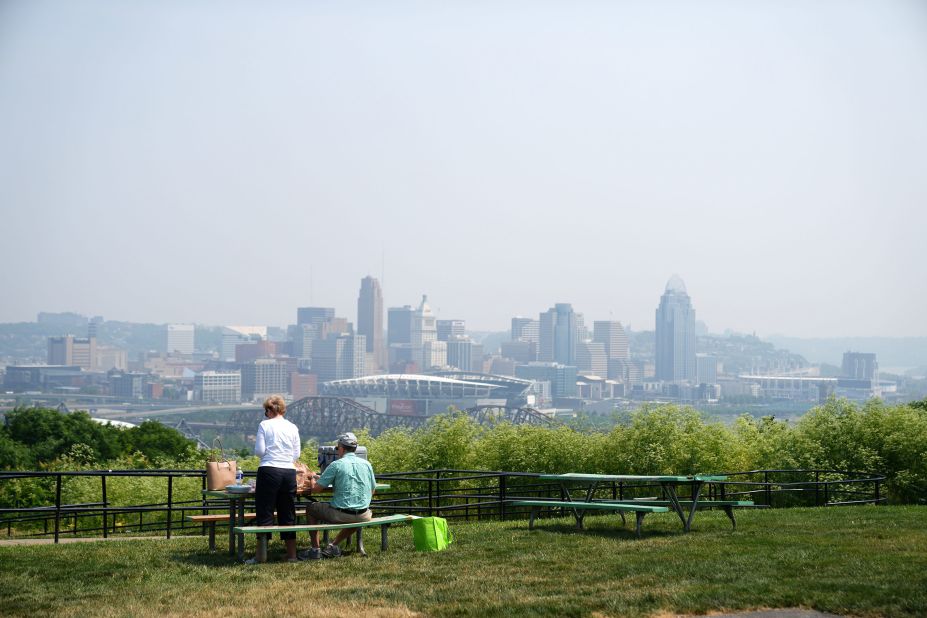 A couple sits for lunch in Cincinnati on June 6. Smoke from the Canadian wildfires had drifted to the city, causing the air to appear hazy.