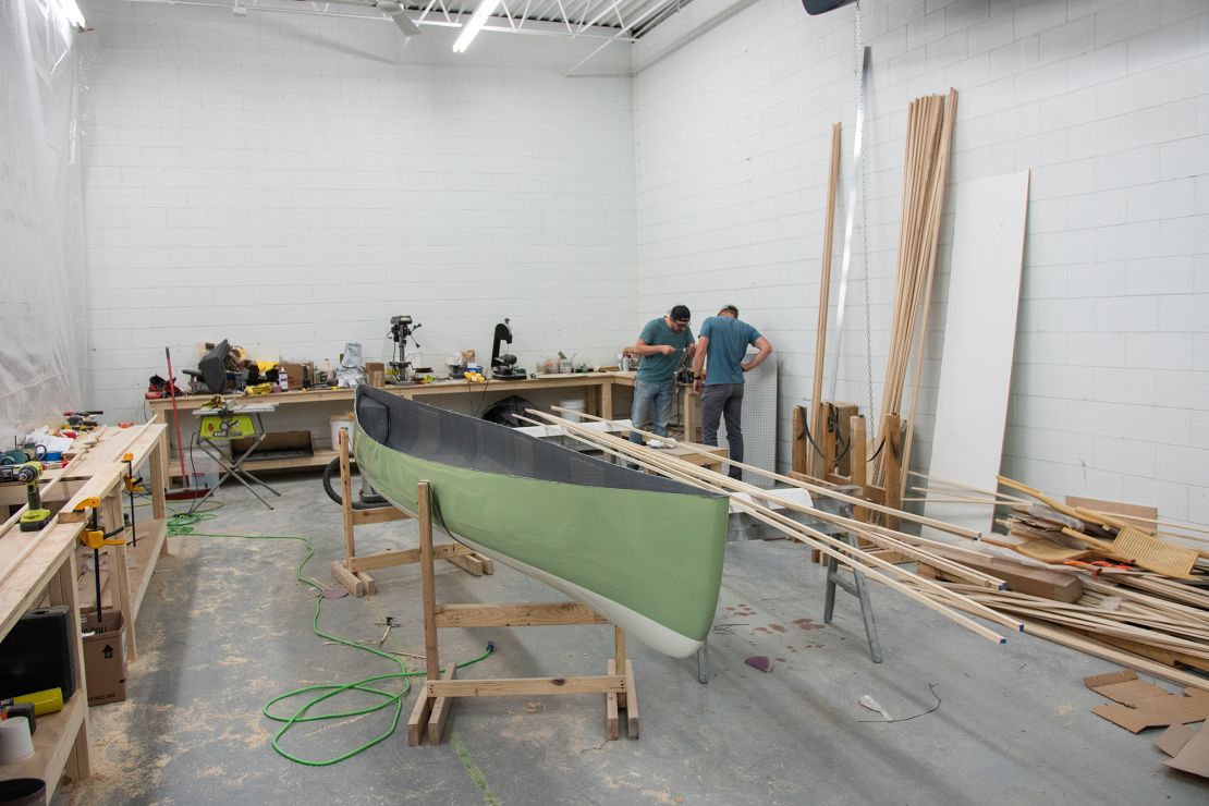 Grey Duck Outdoor's owner Rob Bossen and full-time employee Eli Nord during hull lamination process.