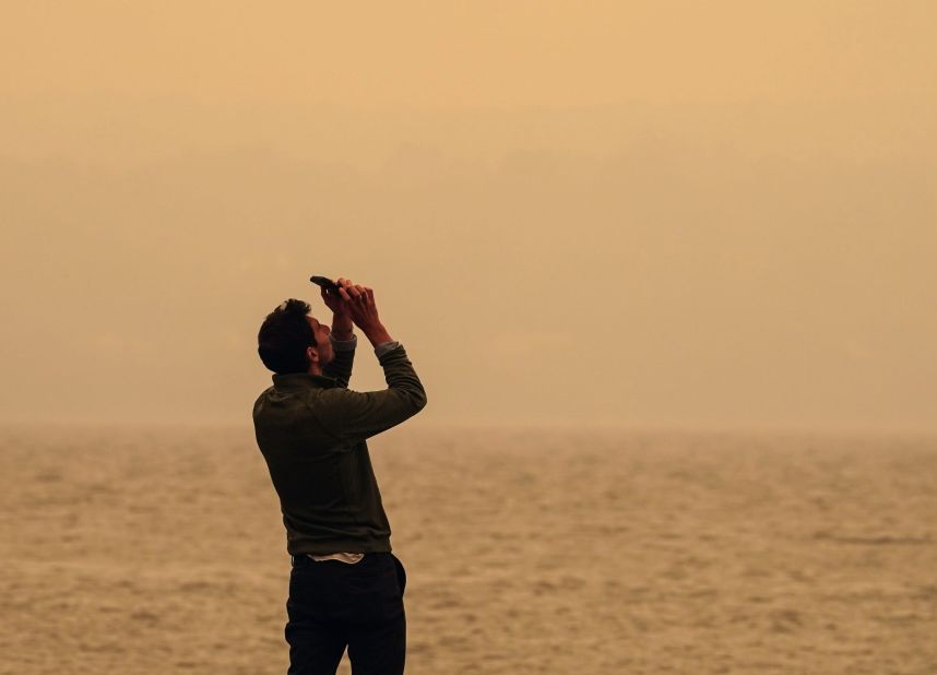 A man in Piermont, New York, attempts to photograph the sun obscured by smoke on June 7.