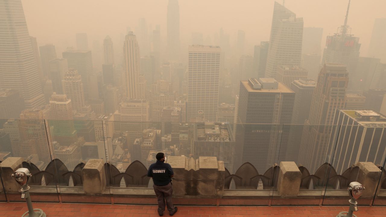 Một nhân viên bảo vệ nhìn ra từ đỉnh của Trung tâm Rockefeller ở New York khi thành phố bị sương mù bao phủ vào ngày 7/6.