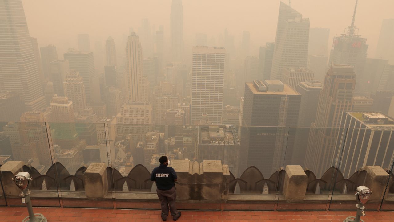 A security guard looks out from the top of the Rockefeller Center in New York as the city is covered with smog on June 7.