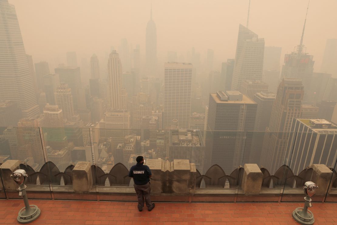 A security guard looks out from the top of the Rockefeller Center in New York as the city is covered with smog on June 7.