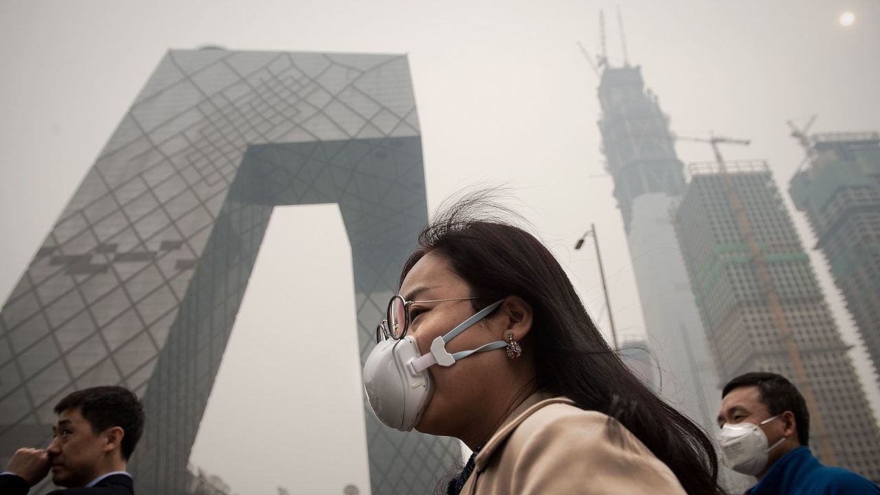 A woman wearing a protective pollution mask on a street in Beijing on March 20, 2017.