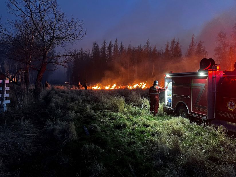 Firefighters battle a wildfire in Evansburg, Alberta, on June 8.