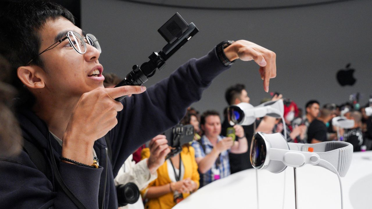 People use phones as Apple's Vision Pro headsets are on display at Apple's annual Worldwide Developers Conference at the company's headquarters in Cupertino, California, U.S. June 5, 2023. REUTERS/Loren Elliott 