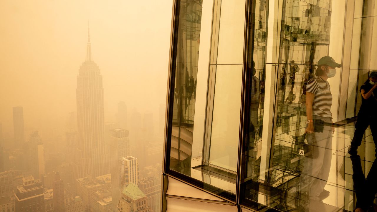 NEW YORK, NEW YORK - JUNE 7: Visitors at Summit One Vanderbilt look out at a smoke-shrouded Manhattan as wildfires in Canada continue to blanket the city on June 7, 2023 in New York City. New York topped the list of most polluted major cities in the world on Tuesday night, as smoke from the fires continues to blanket the East Coast. (Photo by David Dee Delgado/Getty Images)