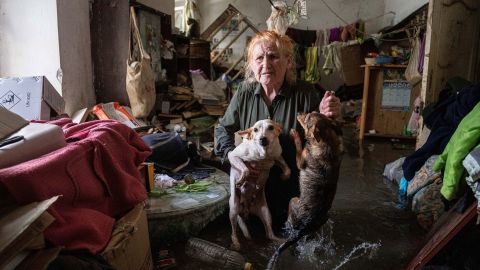 Local resident Tetiana holds her pets, Tsatsa and Chunya, as she stands inside her house that was flooded after the Kakhovka dam blew up overnight, in Kherson, Ukraine, Tuesday, June 6, 2023. Ukraine on Tuesday accused Russian forces of blowing up a major dam and hydroelectric power station in a part of southern Ukraine that Russia controls, risking environmental disaster. (AP Photo/Evgeniy Maloletka)