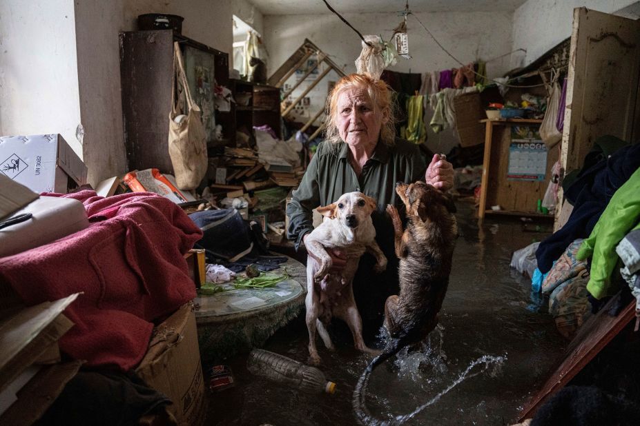 Local resident Tetiana holds her pets, Tsatsa and Chunya, inside her flooded house in Kherson, Ukraine, on Tuesday, June 6. <a href=
