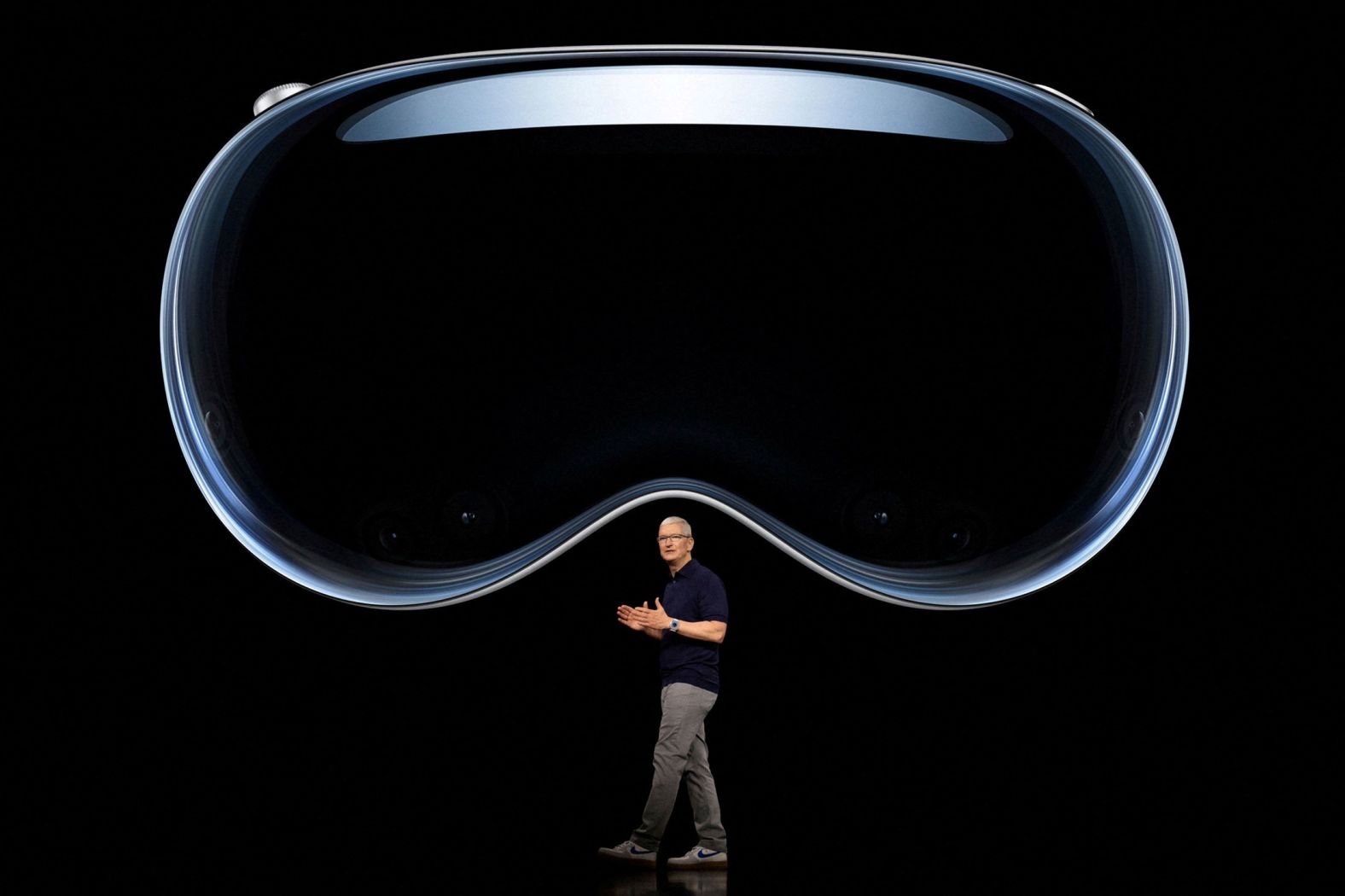 Apple CEO Tim Cook speaks under an image of <a href="https://www.cnn.com/2023/06/05/tech/wwdc-2023-apple-event/index.html" target="_blank">Vision Pro</a>, a new mixed reality headset that the company unveiled at a developer event in Cupertino, California, on Monday, June 5.