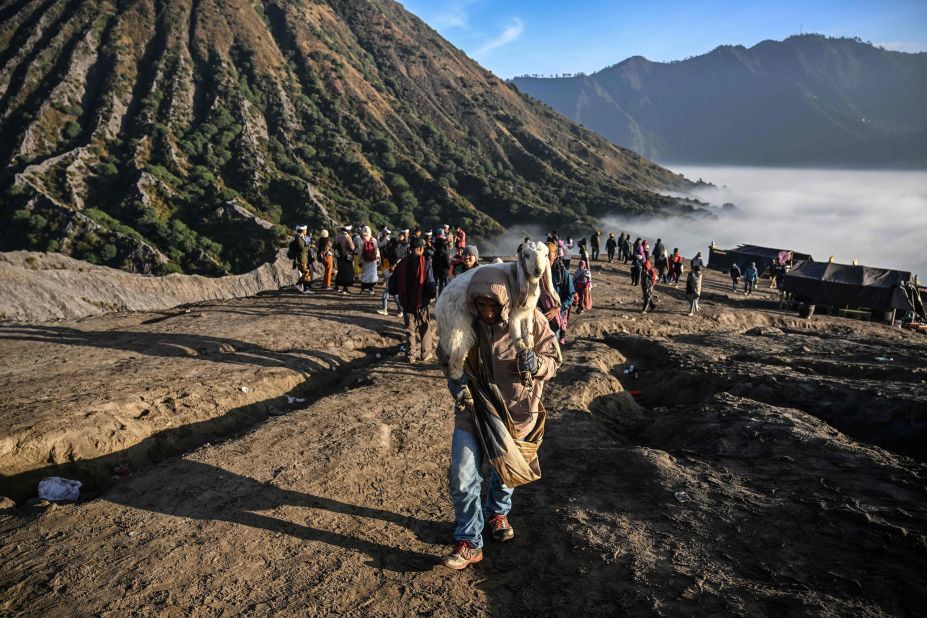 A man carries a goat for offering while walking at the active Mount Bromo volcano in Probolinggo, Indonesia, on Monday, June 5. It was part of the Yadnya Kasada Festival, the main festival of the Tenggerese people.