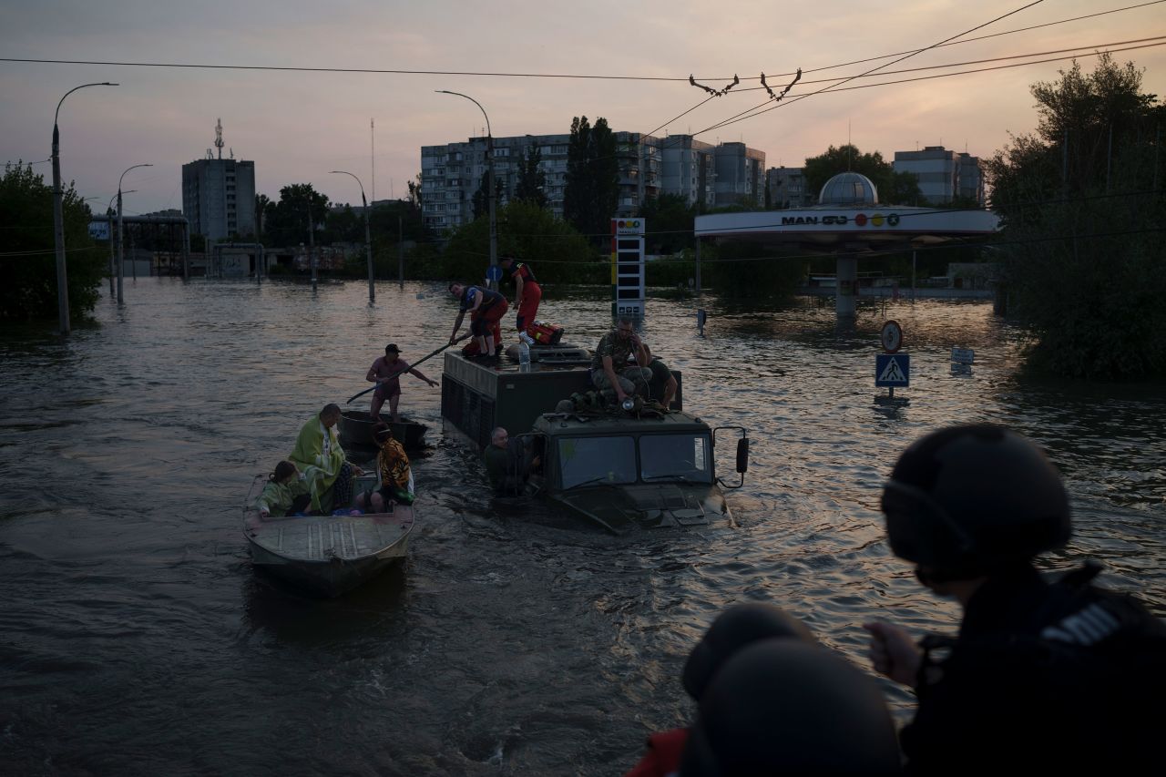 People evacuate a flooded neighborhood in Kherson, Ukraine, after <a href=
