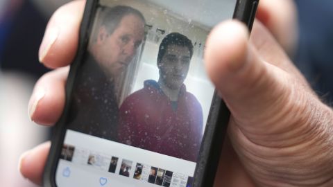 Paul Ventura, father of 18-year-old Mateo Ventura, both of Wakefield, Massachusetts, displays a photograph on his cell phone that shows what he describes as a photo of himself (left) and his son Mateo (right) while speaking with reporters outside federal court on Thursday.