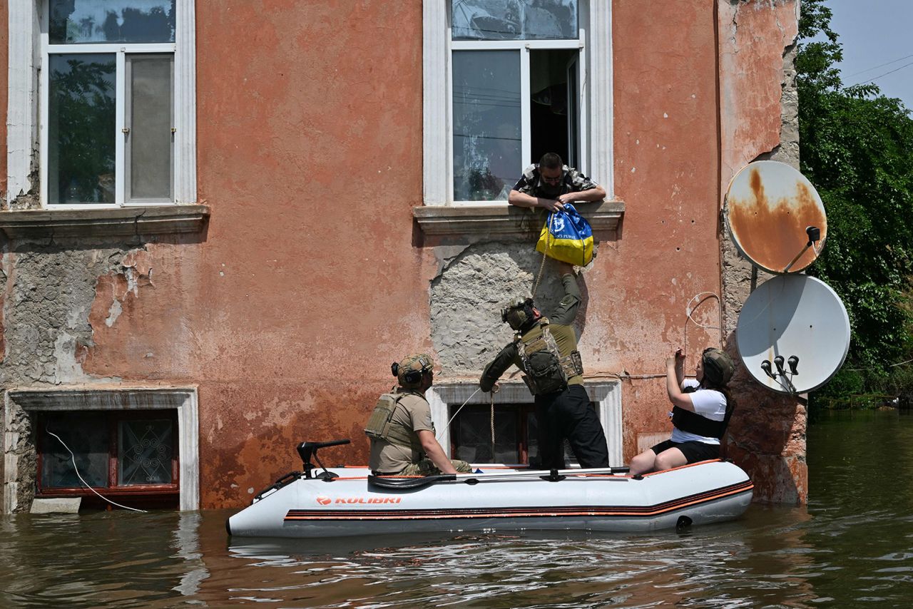 Servicemen of the National Guard of Ukraine deliver food to residents in a flooded area in Kherson on June 8.