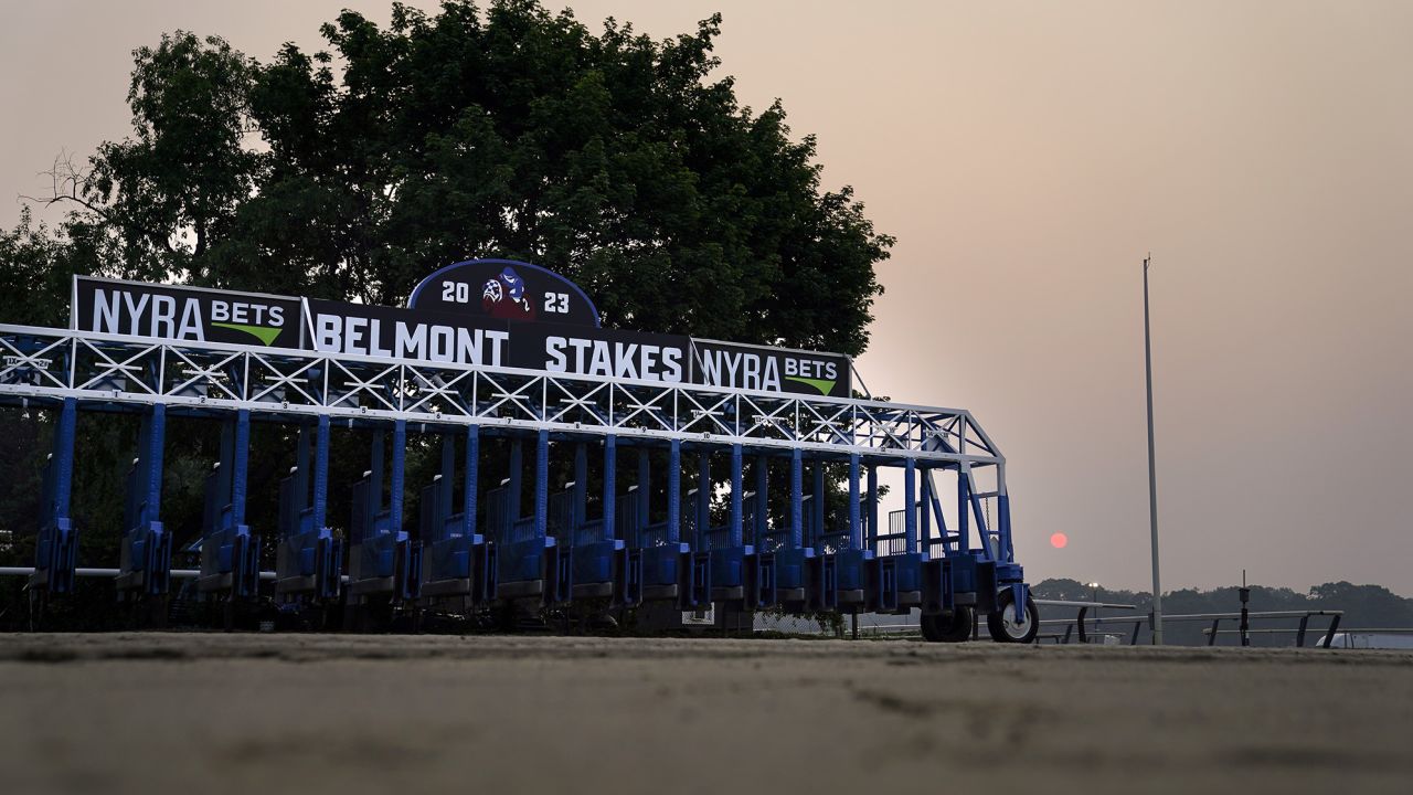 A starting gate rests unused on an empty track as haze from Canadian wildfires obscures the sun ahead of the Belmont Stakes horse race, Thursday, June 8, 2023, at Belmont Park in Elmont, N.Y. Training was cancelled for the day due to poor air quality. (AP Photo/John Minchillo)