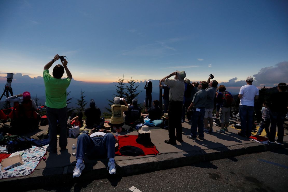 People watch the solar eclipse from Clingmans Dome, which at 6,643 feet (2,025m) is the highest point in the Great Smoky Mountains National Park, Tennessee, U.S. August 21, 2017. Location coordinates for this image are 35º33'24" N, 83º29'46" W. REUTERS/Jonathan Ernst
