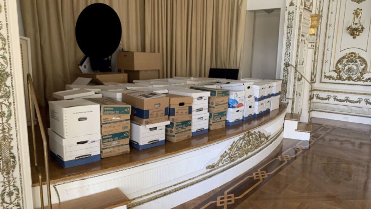 Boxes of classified documents are stored inside the Mar-a-Lago Club's White and Gold Ballroom in this photo included in Donald Trump's federal indictment.