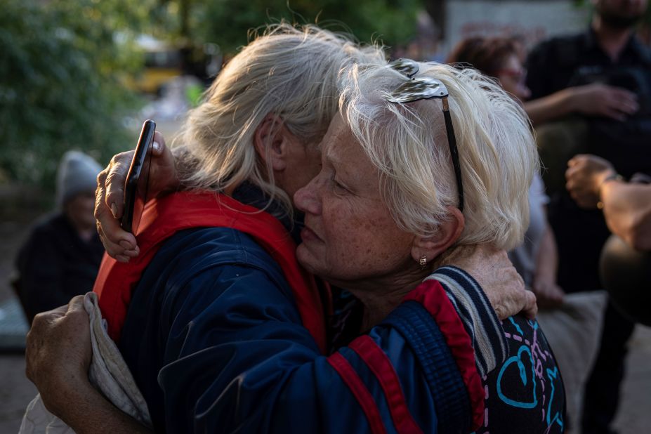 Tetyana, right, hugs her neighbor Hanna as they evacuate from a flooded neighborhood on the bank of the Dnipro River in Kherson on June 9.
