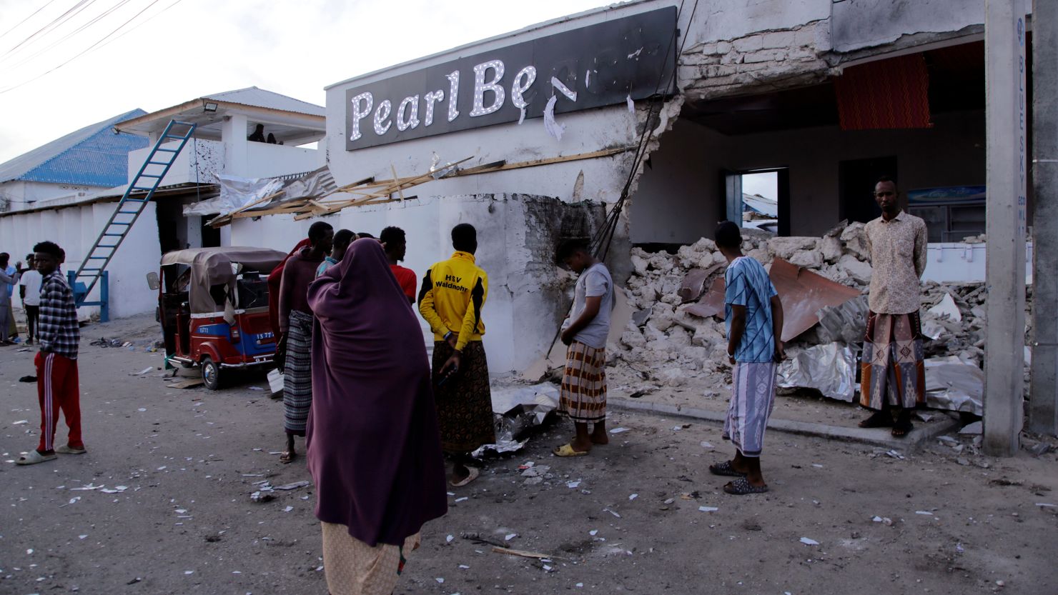 Somalis stand outside the Pearl Beach Hotel on Saturday following a deadly attack.