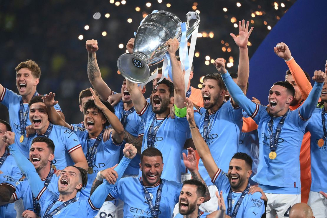 TOPSHOT - Manchester City's German midfielder #8 Ilkay Gundogan (C) lifts the European Cup trophy as they celebrate on the podium after winning the UEFA Champions League final football match between Inter Milan and Manchester City at the Ataturk Olympic Stadium in Istanbul, on June 10, 2023. (Photo by FRANCK FIFE / AFP) (Photo by FRANCK FIFE/AFP via Getty Images)