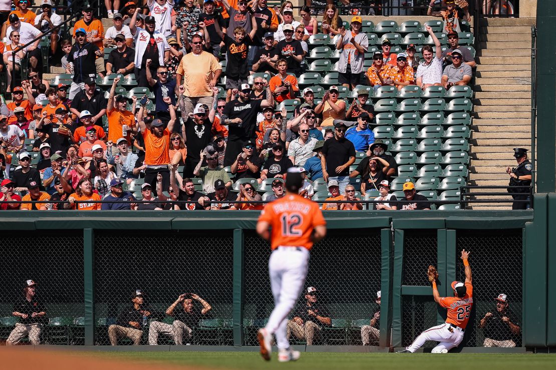 BALTIMORE, MD - JUNE 10: Fans react as Anthony Santander #25 of the Baltimore Orioles makes a catch as he crashes with the wall in the first inning against the Kansas City Royals at Oriole Park at Camden Yards on June 10, 2023 in Baltimore, Maryland.